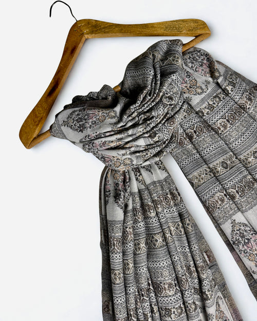 Silver grey Indian pashmina shawl laid flat, banded rows of paisley buta and geometric stripes with a plain ivory end panel