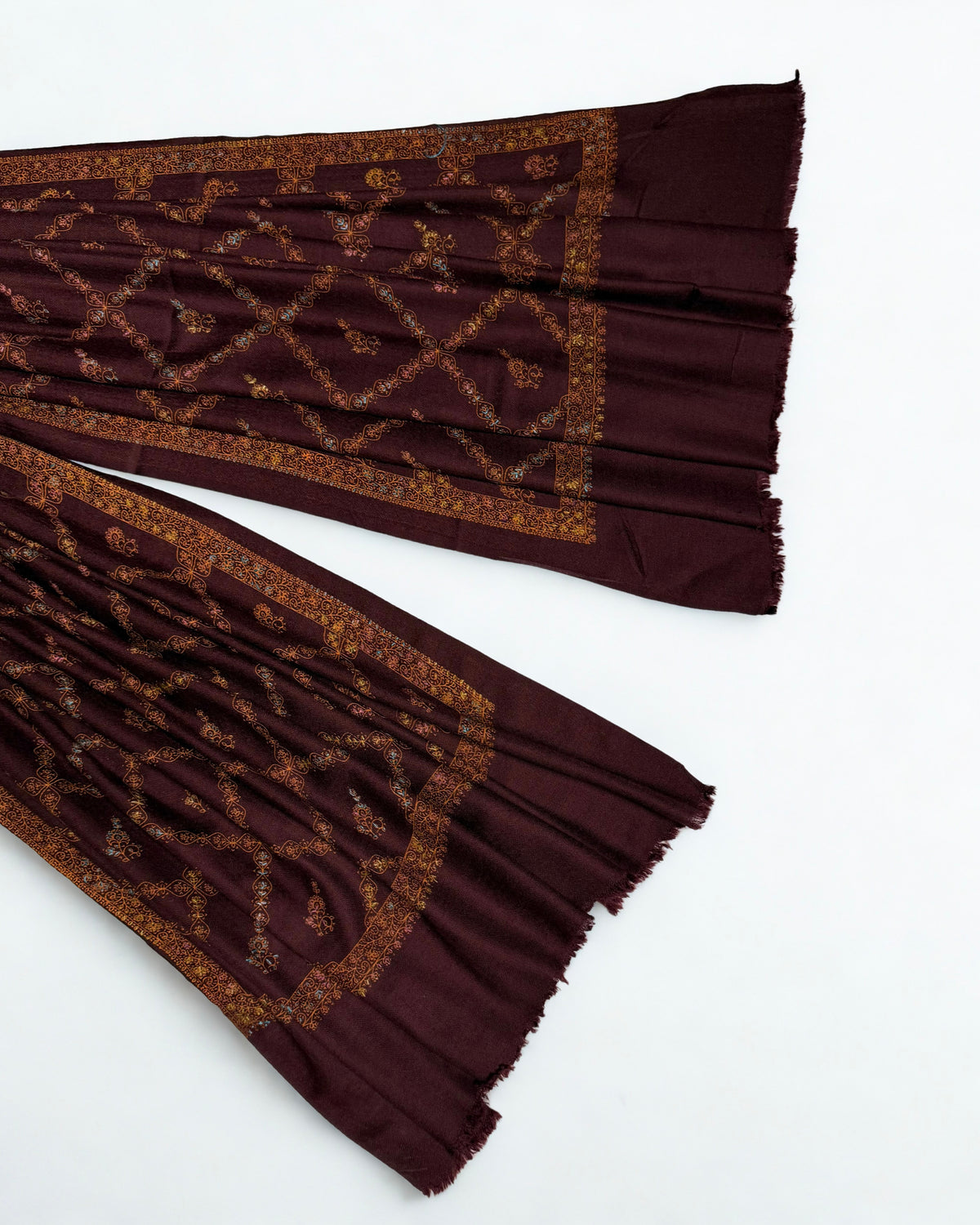 Ends of the wine Swati Shahtoosh shawl showing the wide scrolling border and fringed edge
