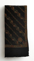 Black Swati Shahtoosh shawl folded, showing diagonal rows of hand-embroidered paisley and vine, corner medallion, embroidered border and plain fringed end