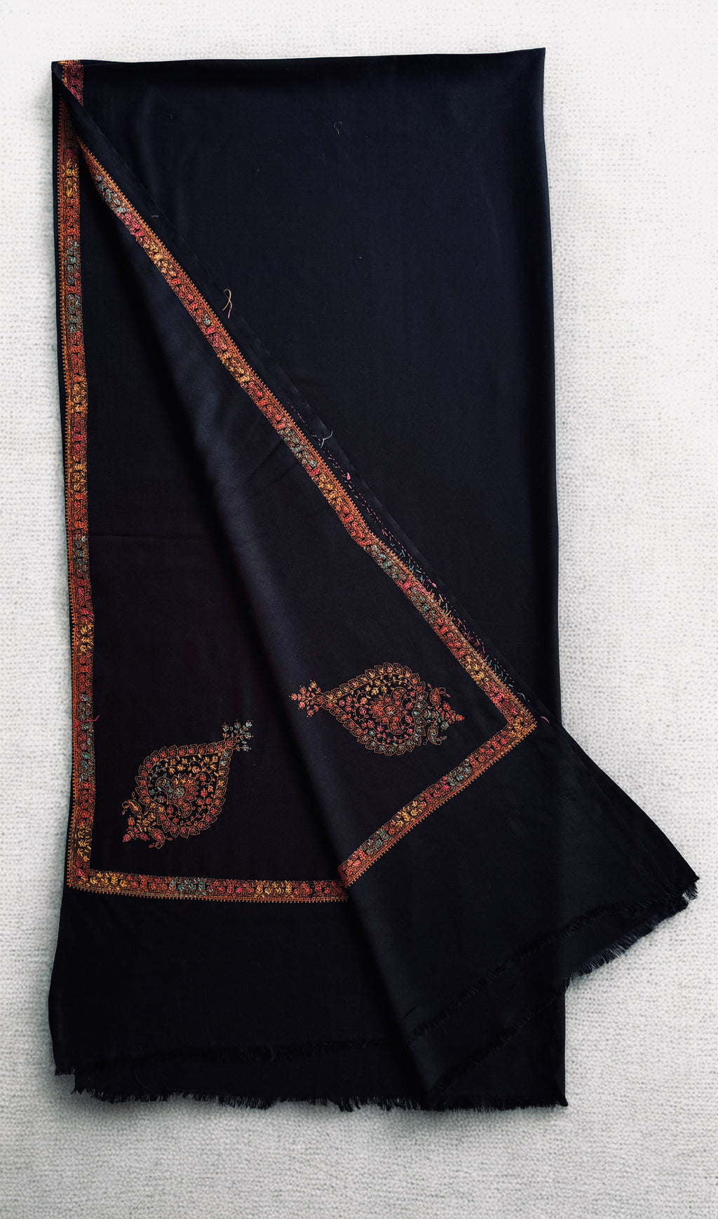 Black Swati Shahtoosh shawl with a large hand-embroidered corner paisley, folded