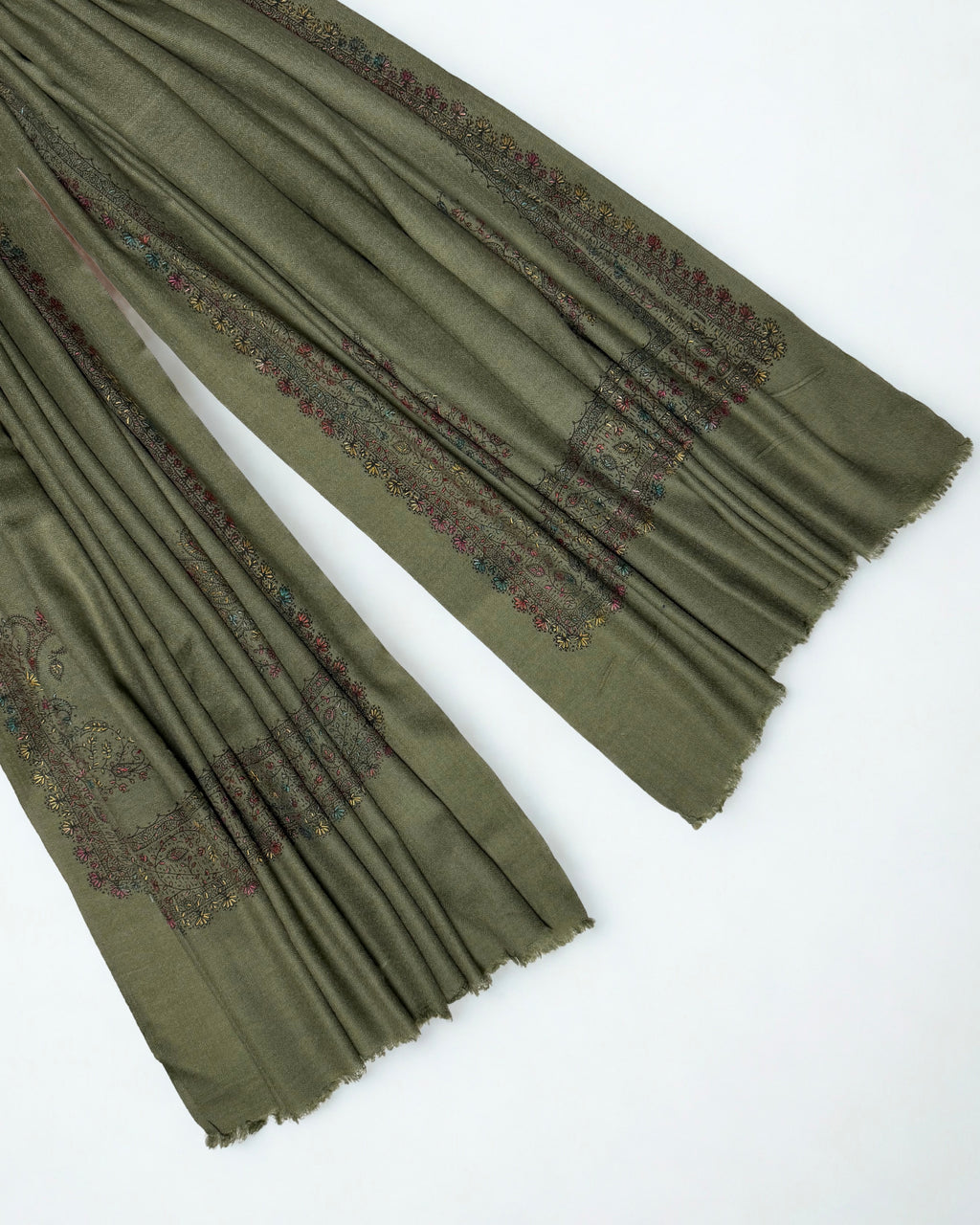 Ends of the olive green Swati Shahtoosh shawl showing the embroidered border and corner paisley