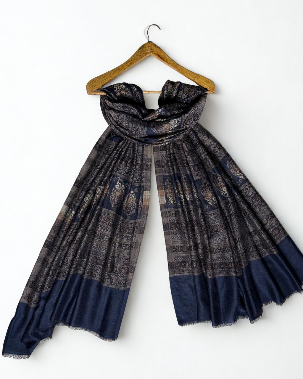 Indigo and bronze Indian pashmina shawl laid flat, banded rows of large floral buta on indigo with fine geometric stripes and a plain indigo end panel