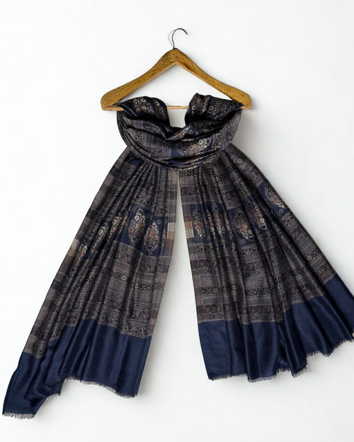 Indigo and bronze Indian pashmina shawl laid flat, banded rows of large floral buta on indigo with fine geometric stripes and a plain indigo end panel
