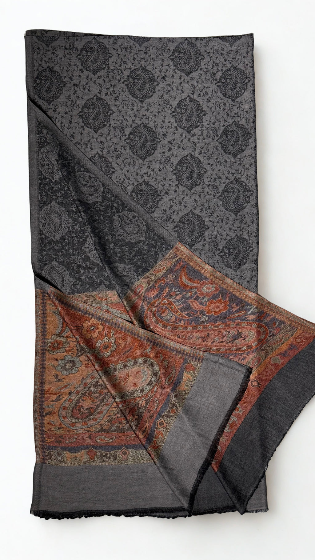Charcoal fine pashmina ring shawl folded with one end turned back, showing the black paisley medallion lattice and large rust paisley pallu