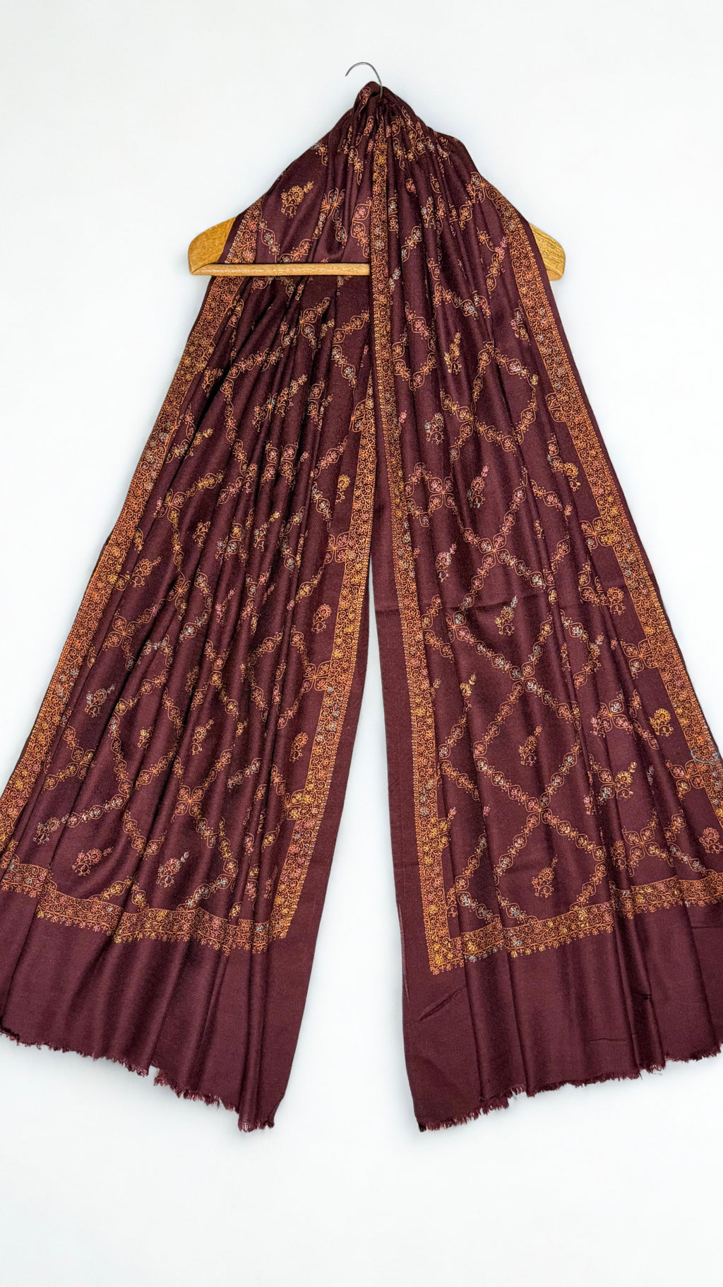 Wine Swati Shahtoosh shawl on a hanger, copper jaal embroidery running the full length