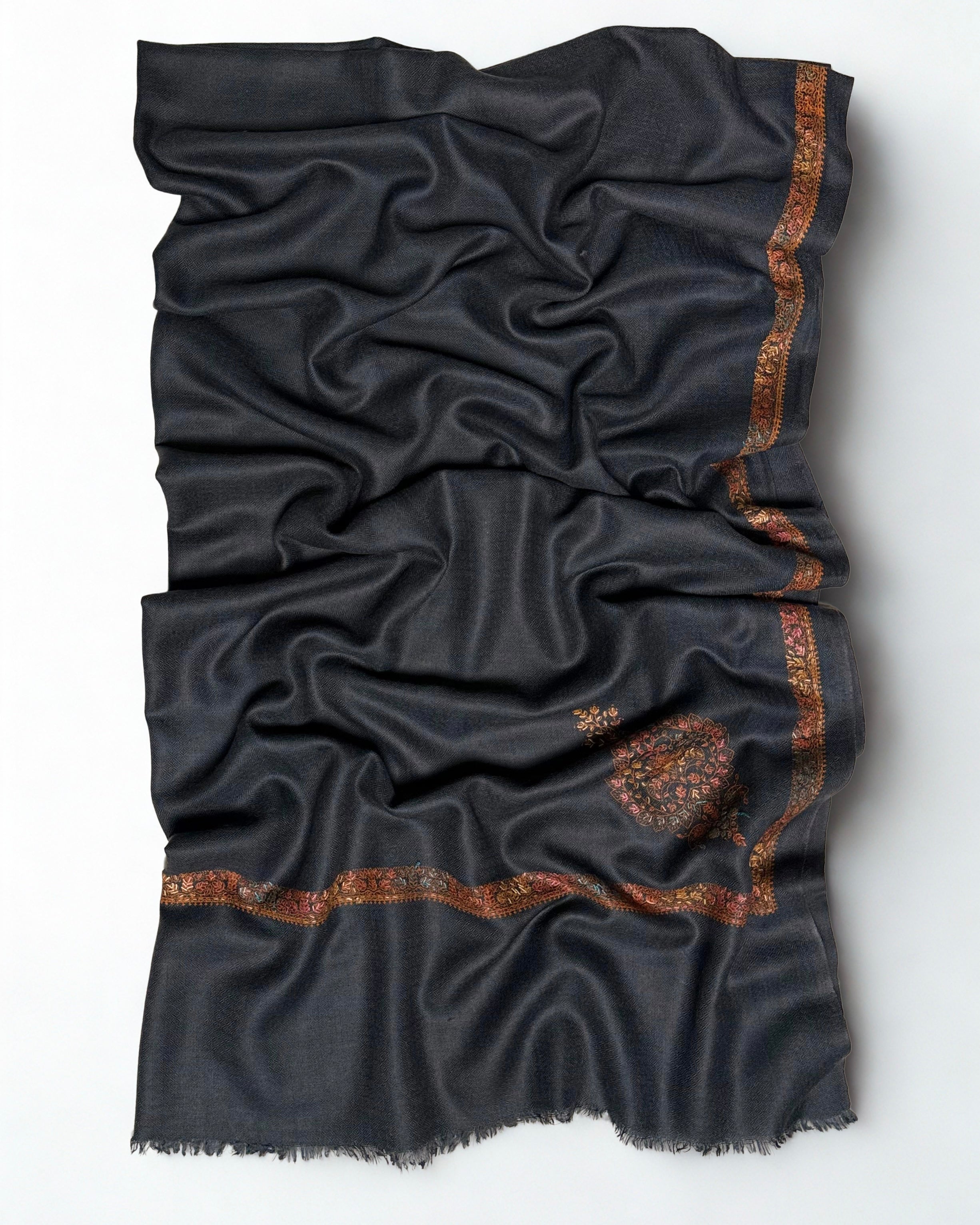 Charcoal grey Swati Shahtoosh shawl folded back to show both corner buta and the hand-embroidered border meeting at the corner