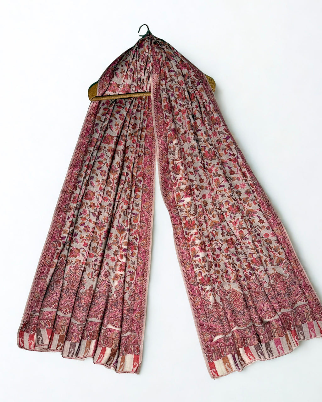 Oyster Kani pashmina shawl laid flat, rose and terracotta floral field with a scalloped medallion border and striped paisley end panel