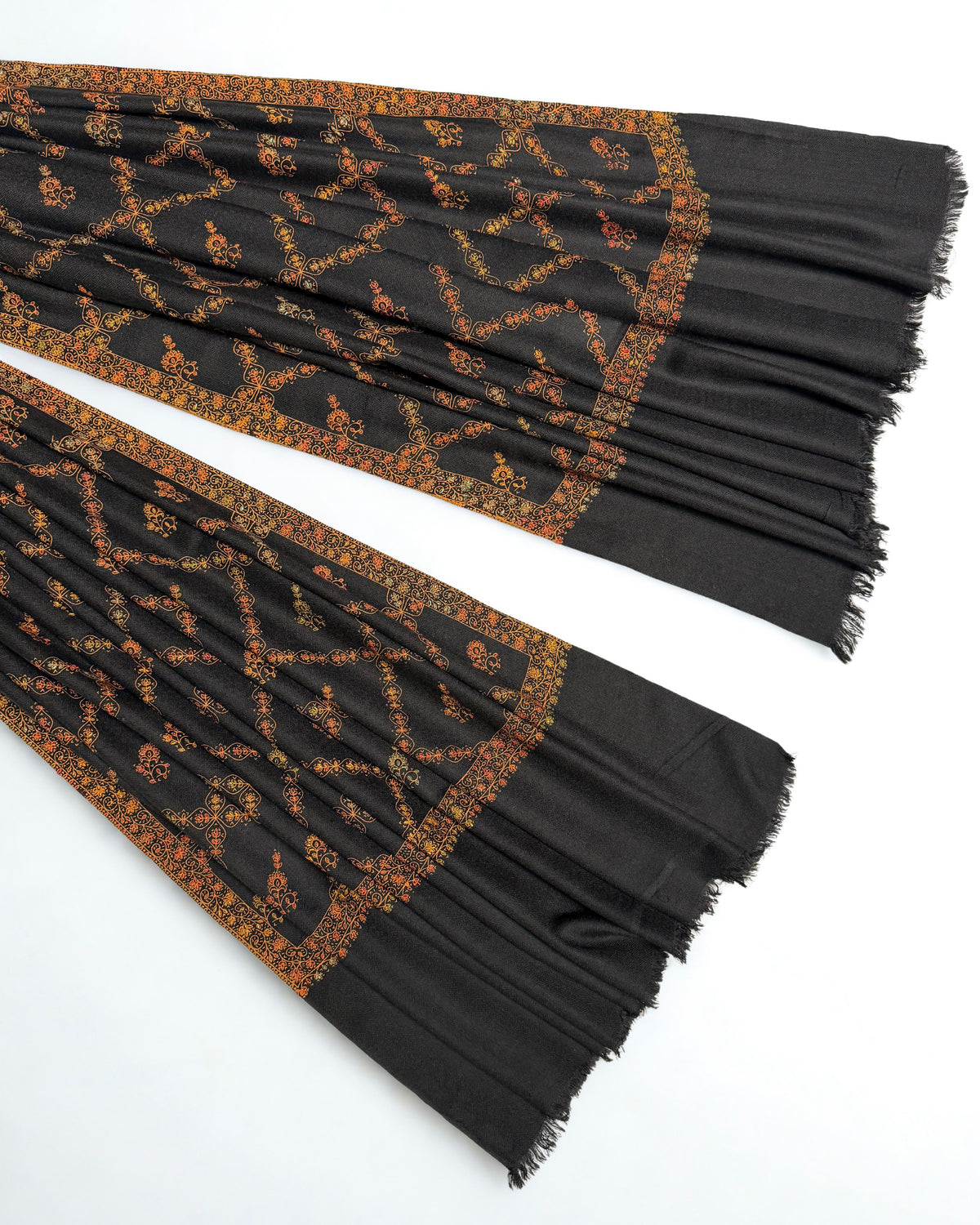 Ends of the black Swati Shahtoosh shawl showing the gold jaal lattice, deep border and fringed edge
