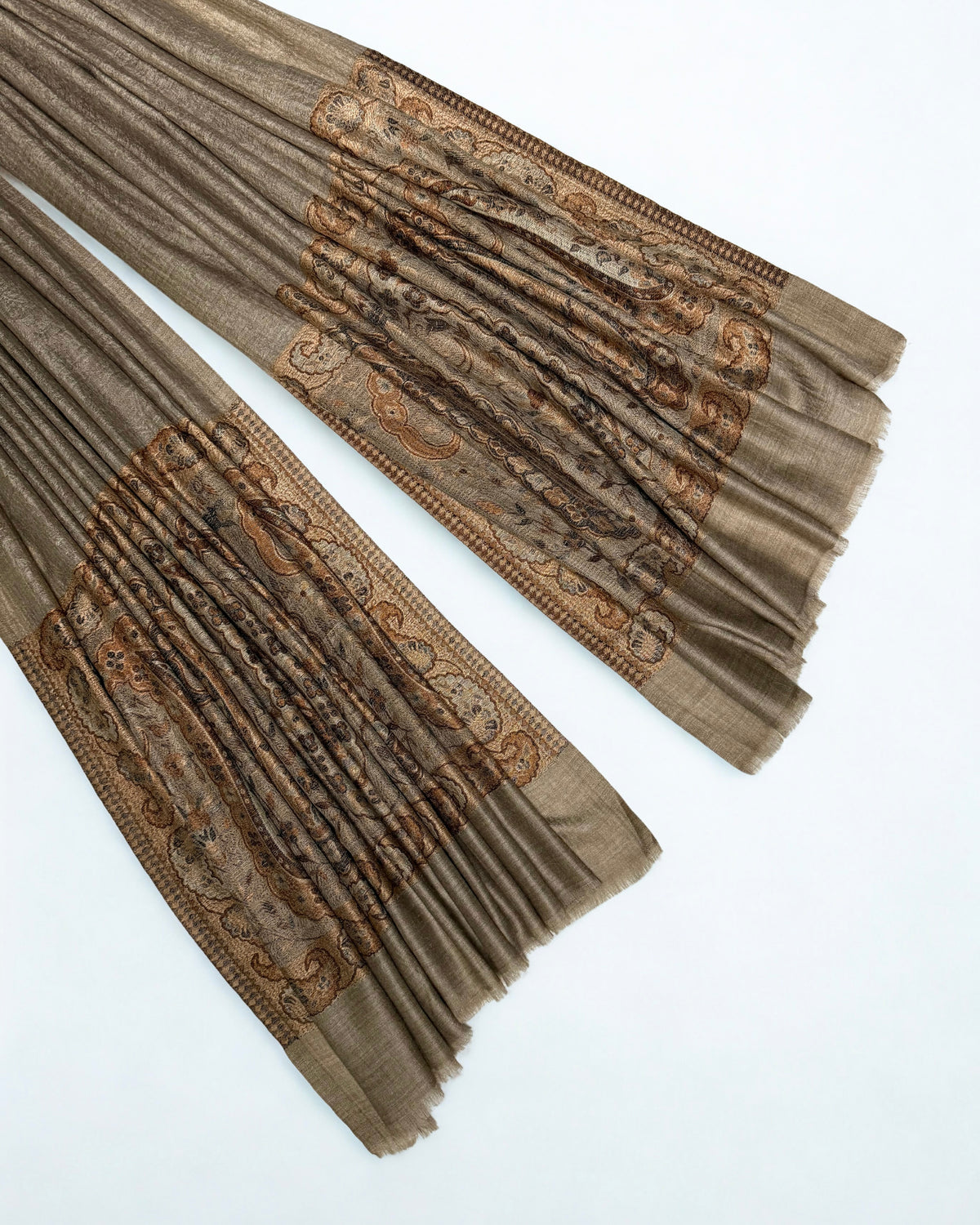Close-up of both ends of a warm khaki pashmina ring shawl, showing the copper, cream and brown woven paisley pallas
