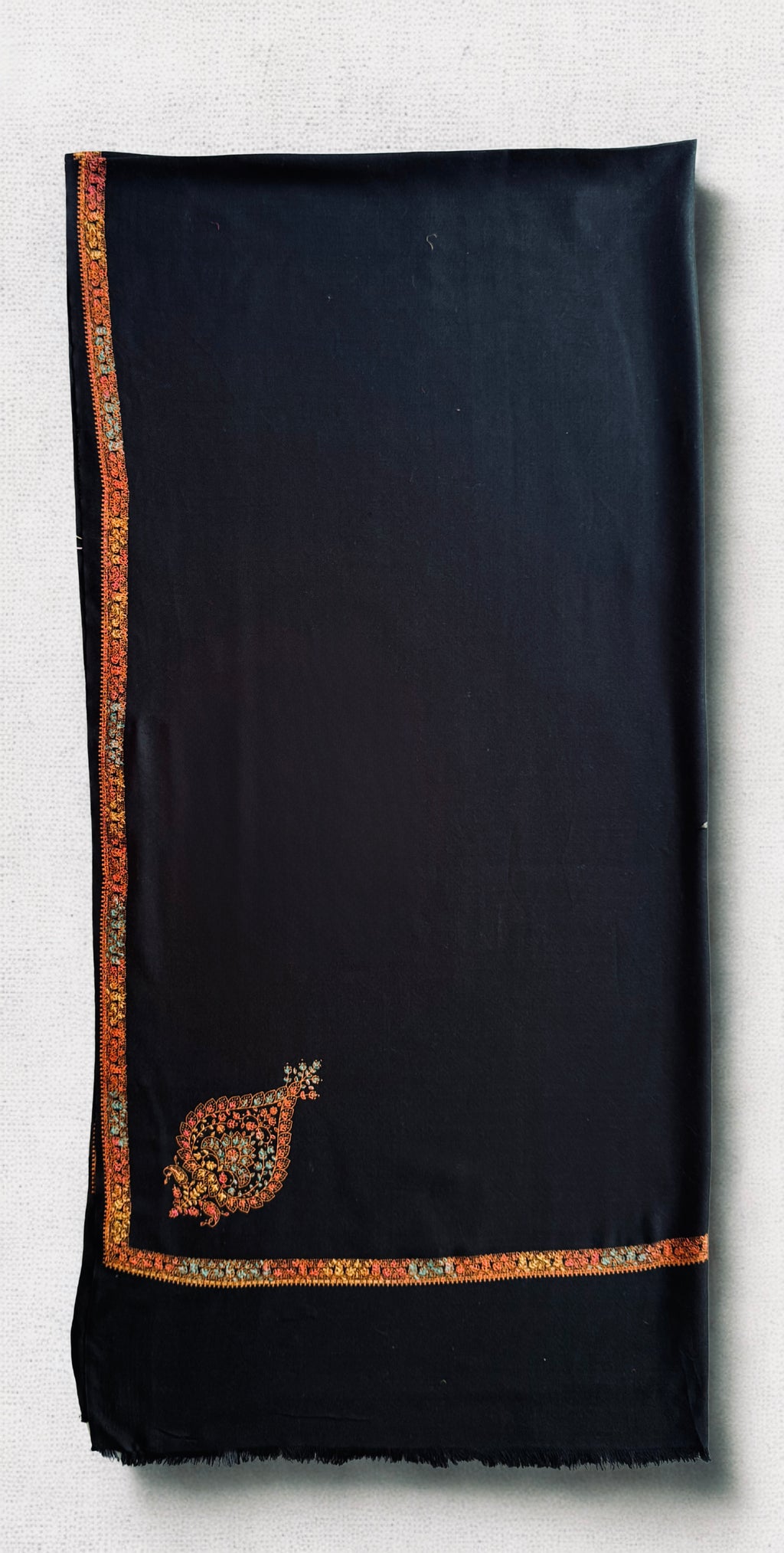 Both corner paisleys and the fine saffron border meeting at the edge of the black shawl