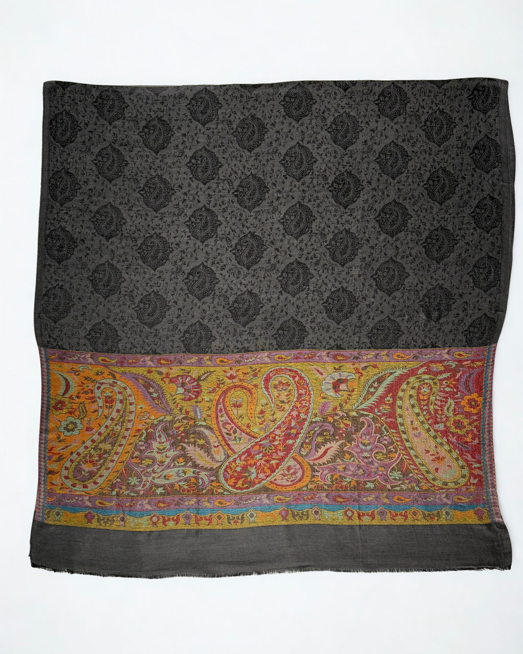 Dark charcoal pashmina ring shawl laid flat, showing the woven black paisley field and large interlocking paisleys across the saffron palla