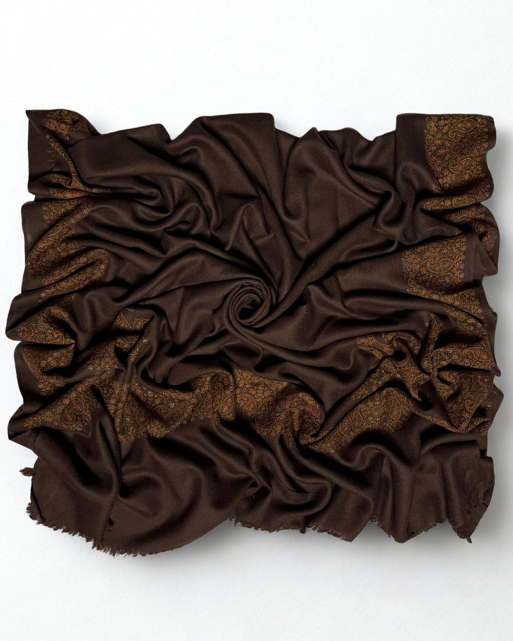 Espresso brown Swati Shahtoosh shawl gathered in folds, the gold and copper paisley border catching the light against the dark ground