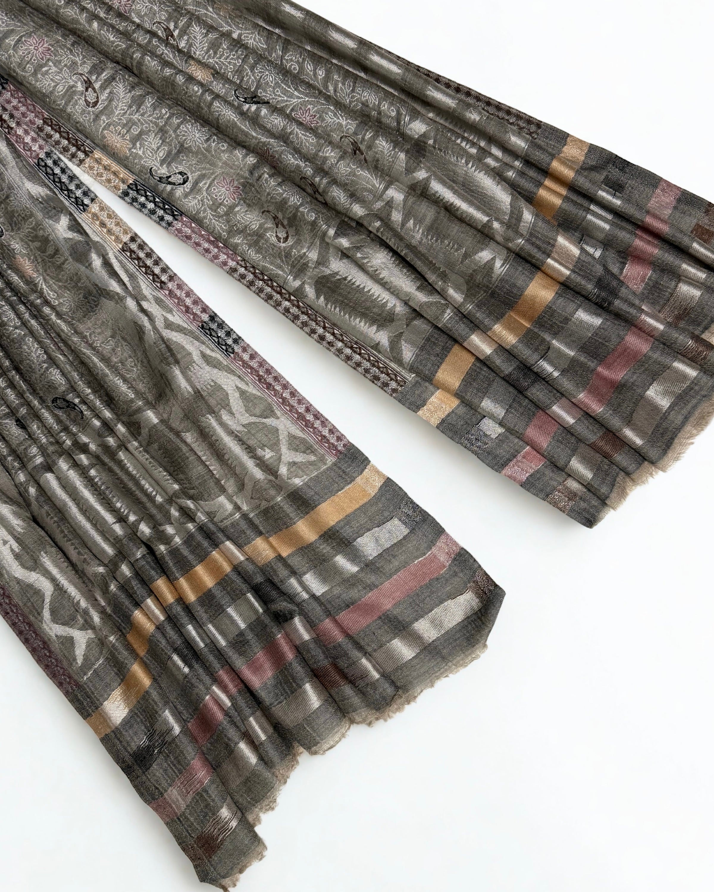 Wide woven border of interlocking medallions running down the side of the shawl