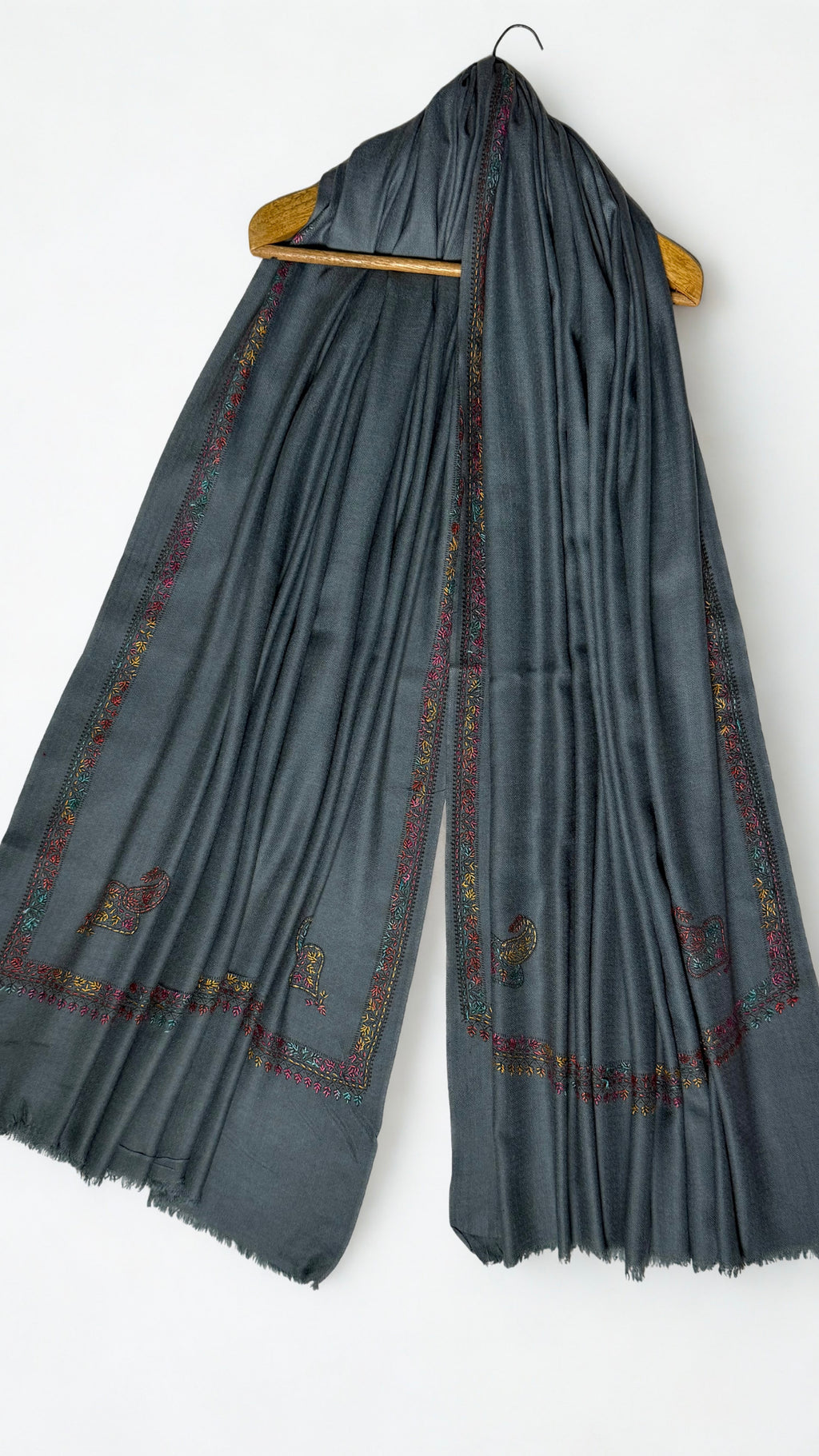 Slate grey Swati Shahtoosh shawl on a hanger, embroidered floral border running down both ends