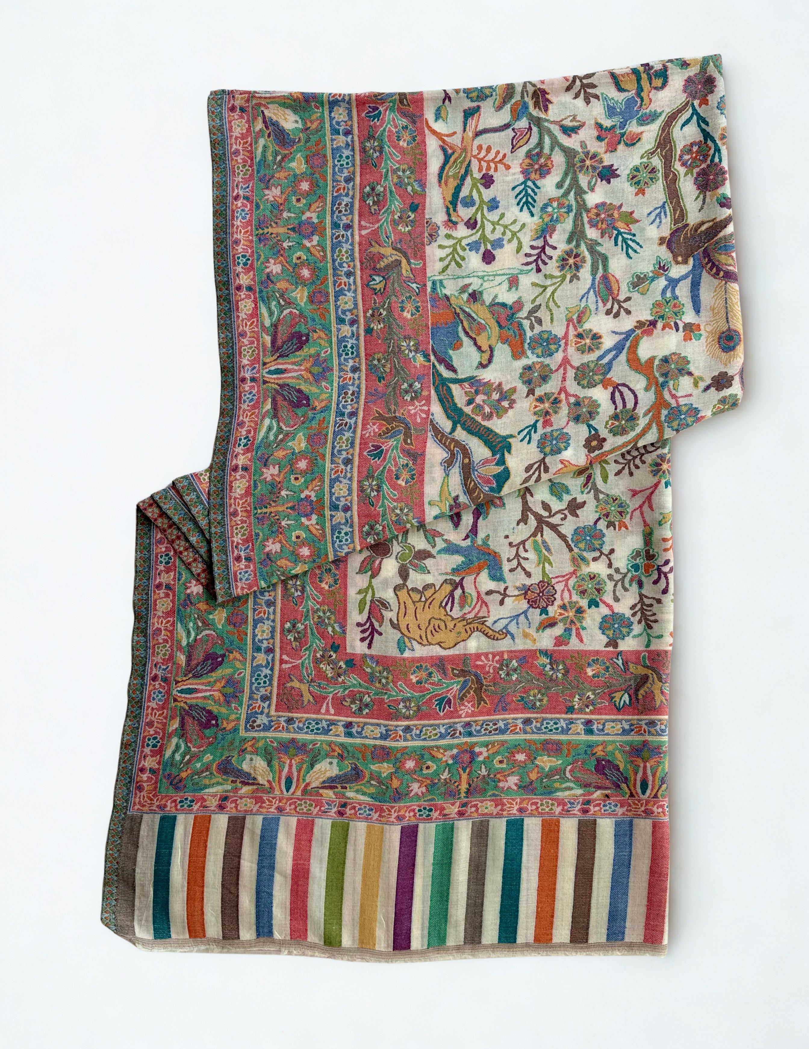 Ivory Kani shikargah pashmina shawl laid flat, birds, deer and leopards woven among flowering trees within four borders and a striped end panel