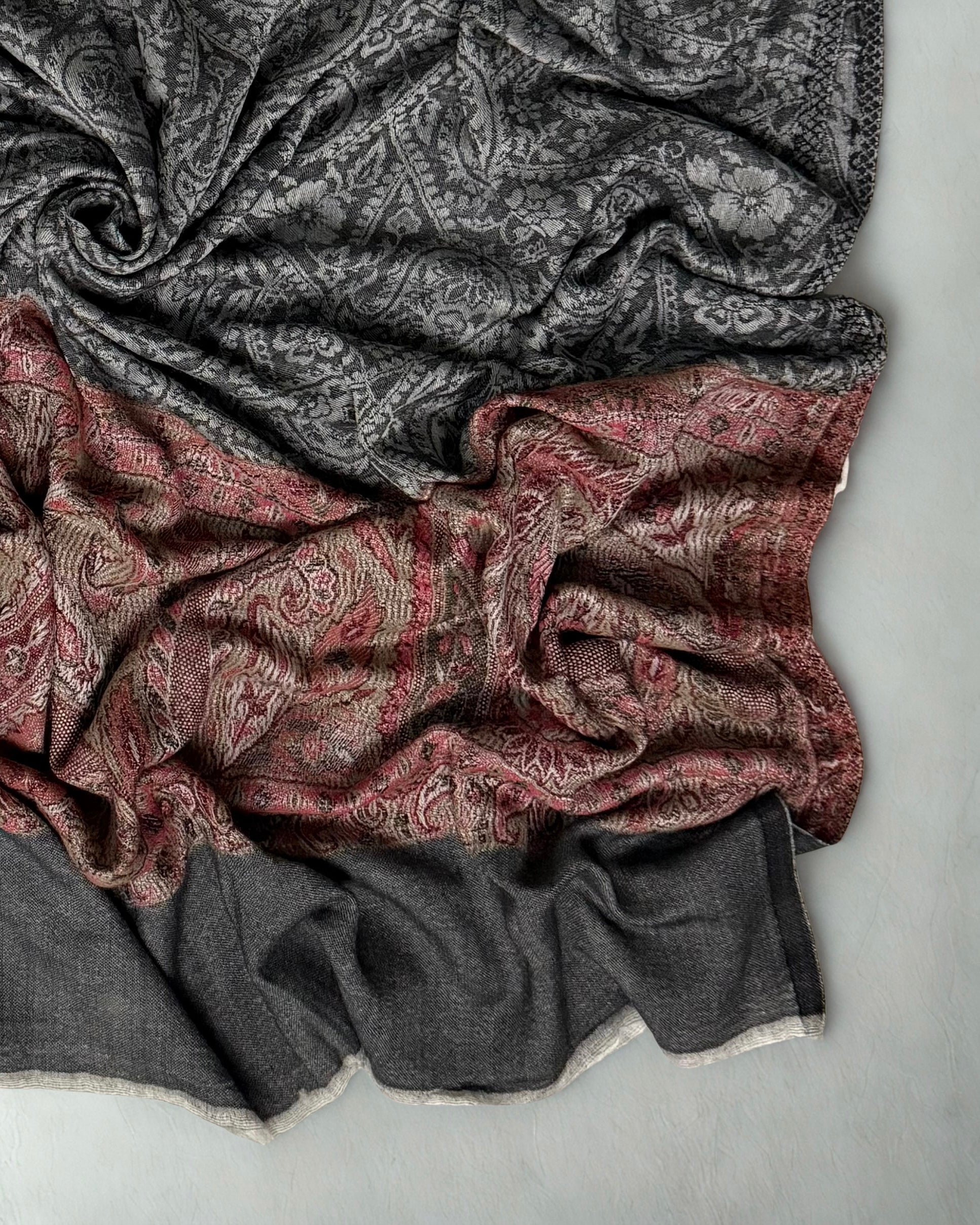 Folded charcoal Palladar shawl showing the plain end panel below the rose border