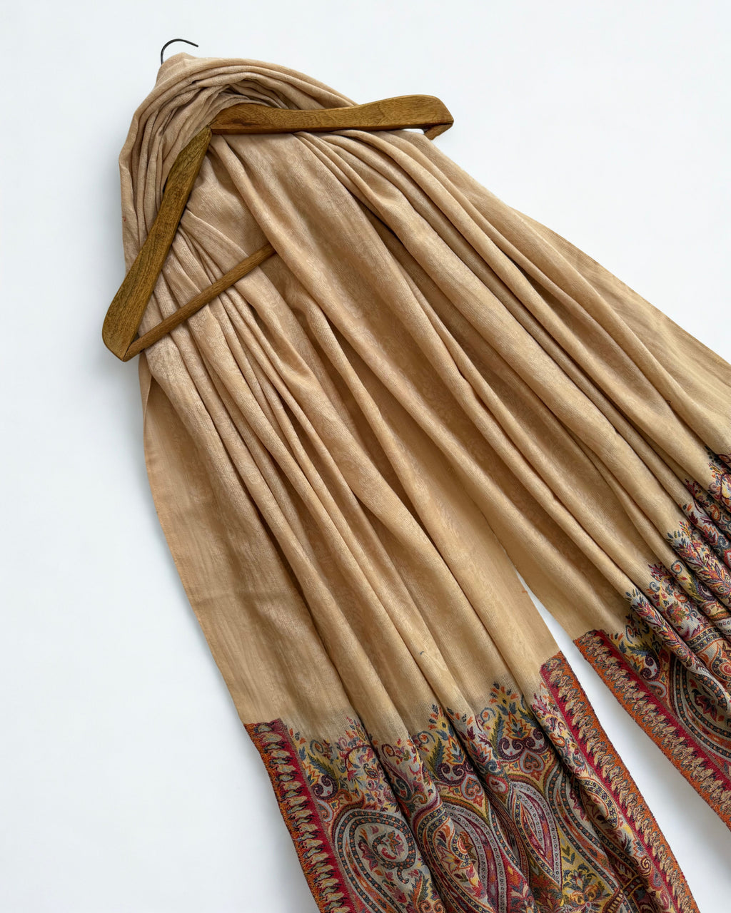 Shawl laid flat showing the self-patterned sand ground and the full end panel