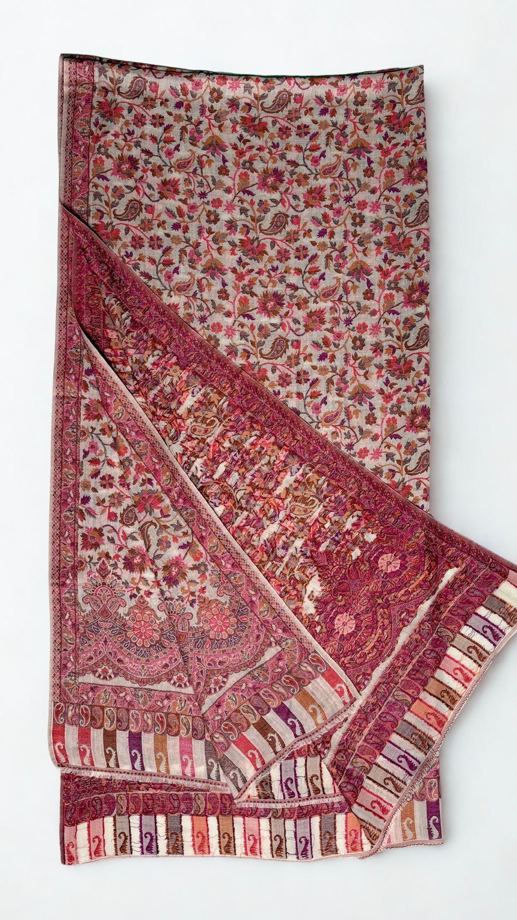 Rose and oyster Kani pashmina shawl folded back to show the scalloped border and the reverse of the handwoven pattern