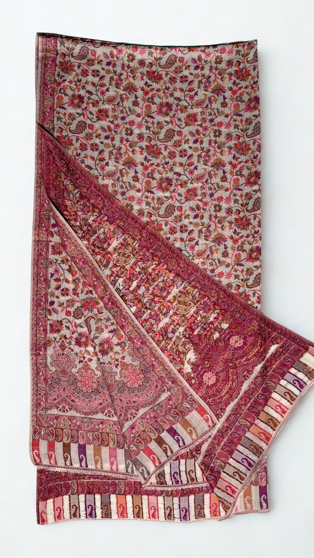 Rose and oyster Kani pashmina shawl folded back to show the scalloped border and the reverse of the handwoven pattern