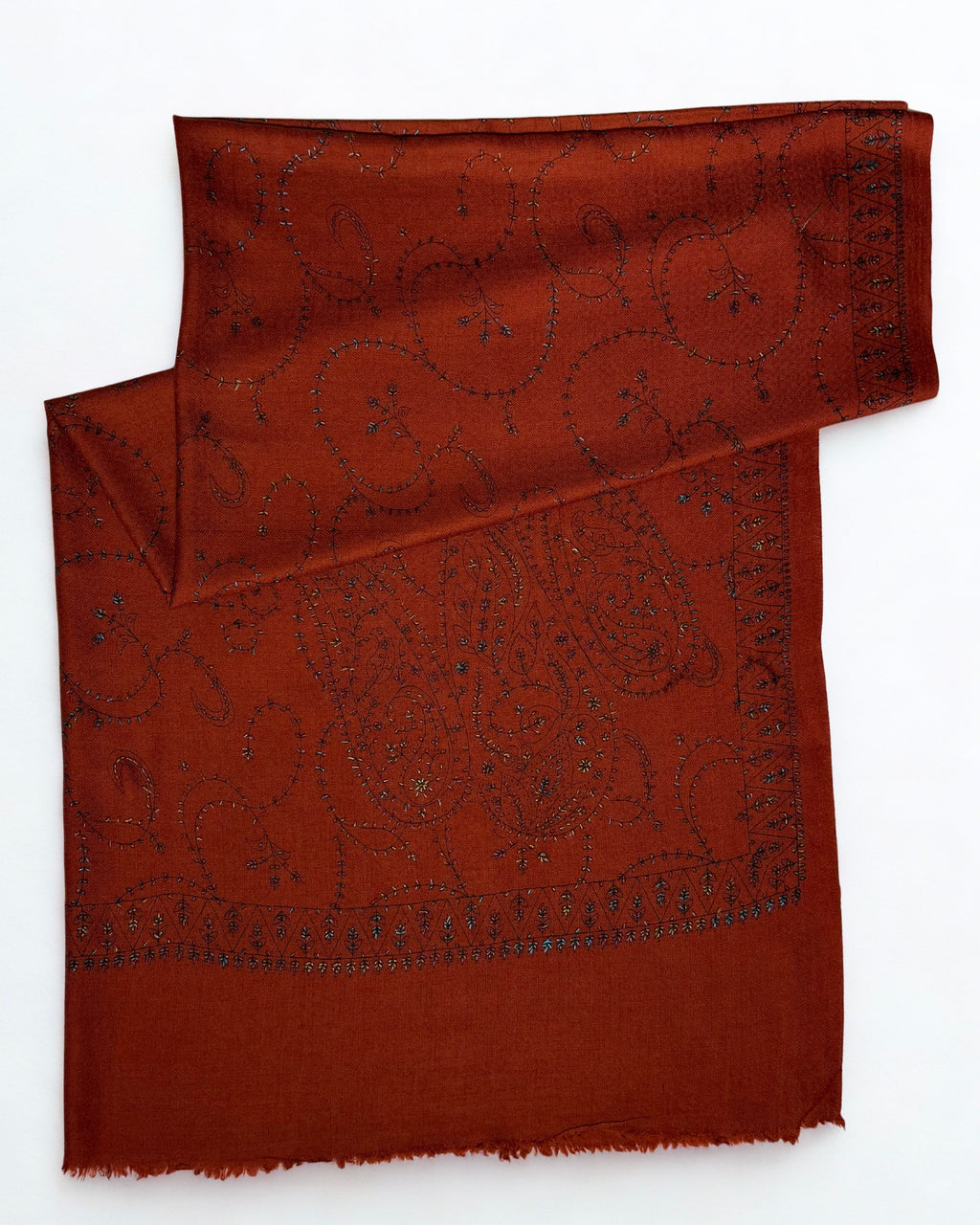 Rust Swati Shahtoosh shawl with one end turned back, showing the embroidered border and fringed edge