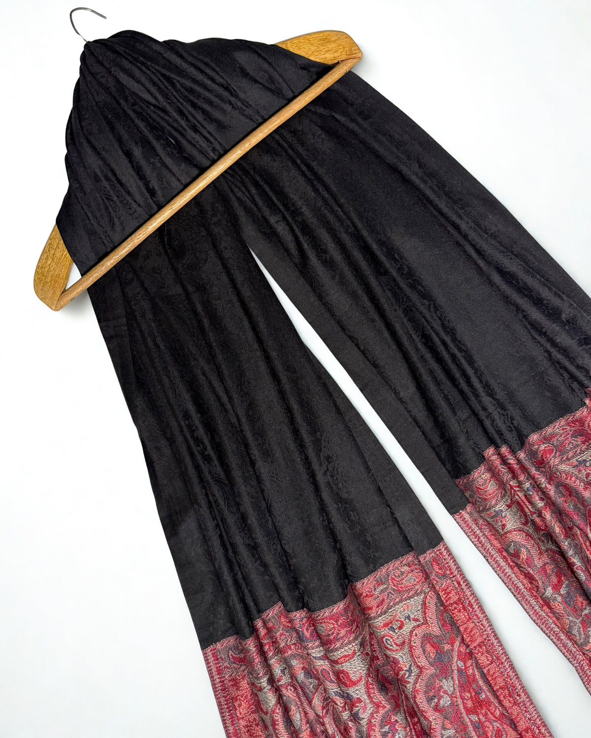 Crimson and silver woven paisley end panels of a black Palladar ring shawl, shown in soft pleats