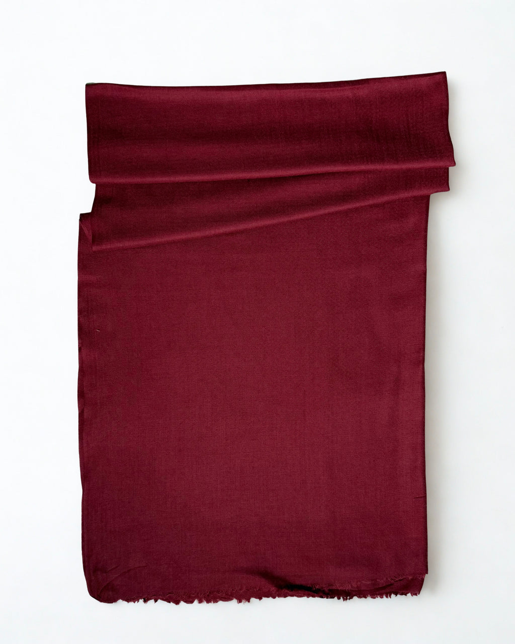 Maroon Swati Shahtoosh shawl folded on a white background, plain with a natural fringed edge