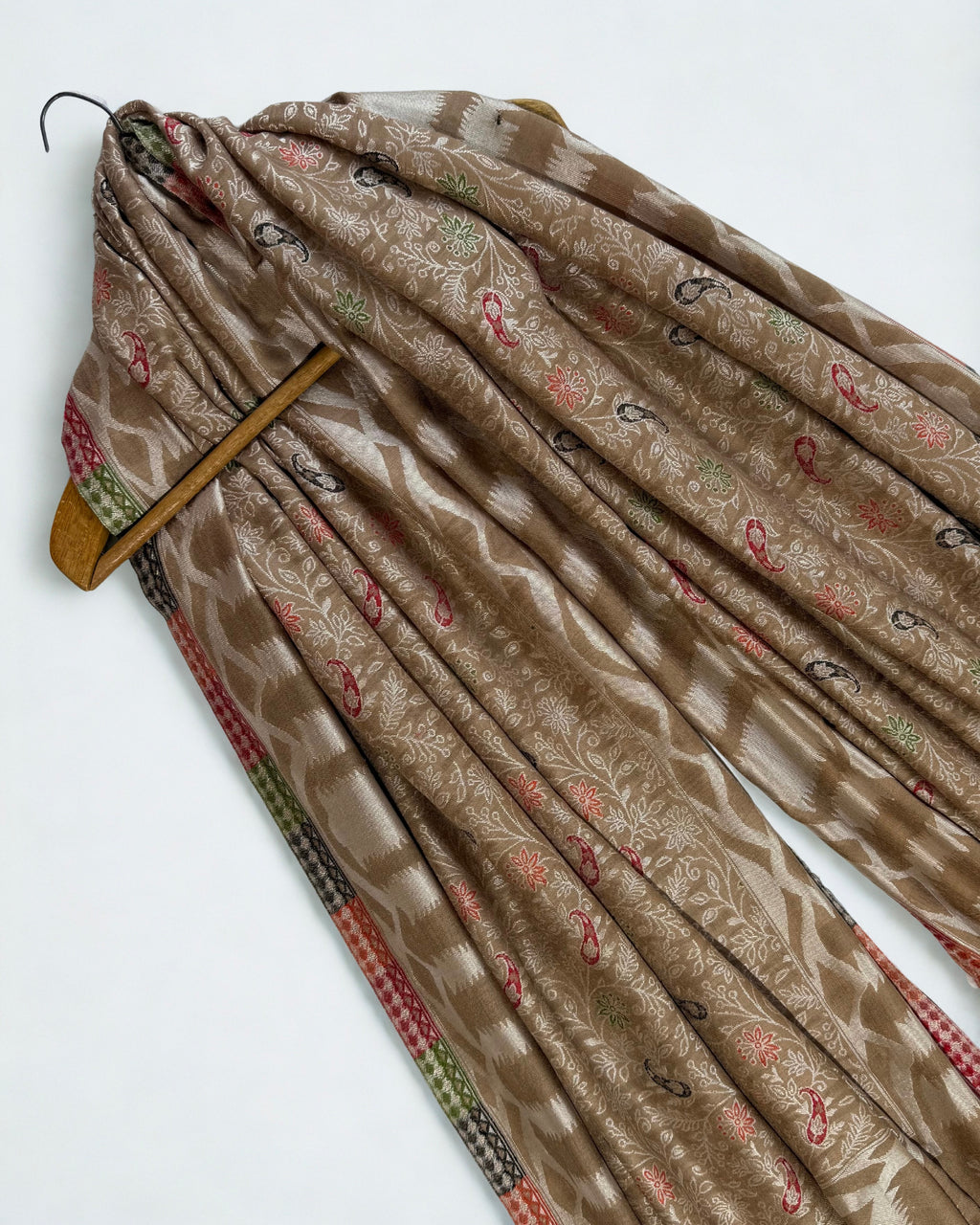 Taupe jamawar shawl on a wooden hanger, showing its drape