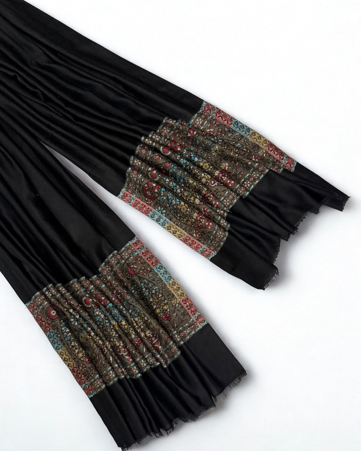 Both ends side by side showing the plain black ground meeting the olive paisley band