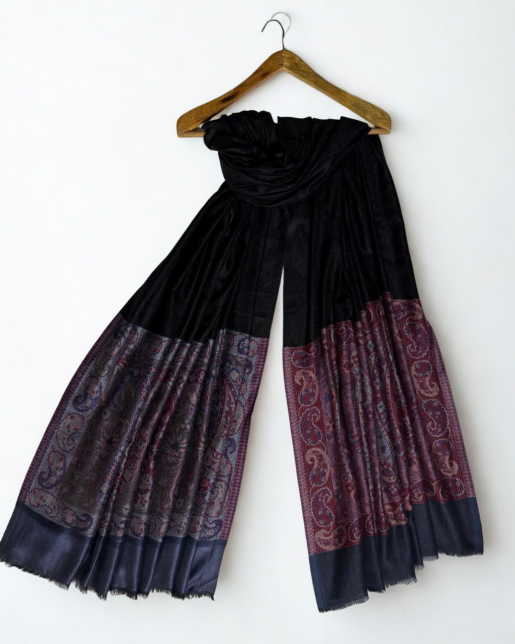 The solid slate blue band that closes the end of the shawl, beyond the paisley border