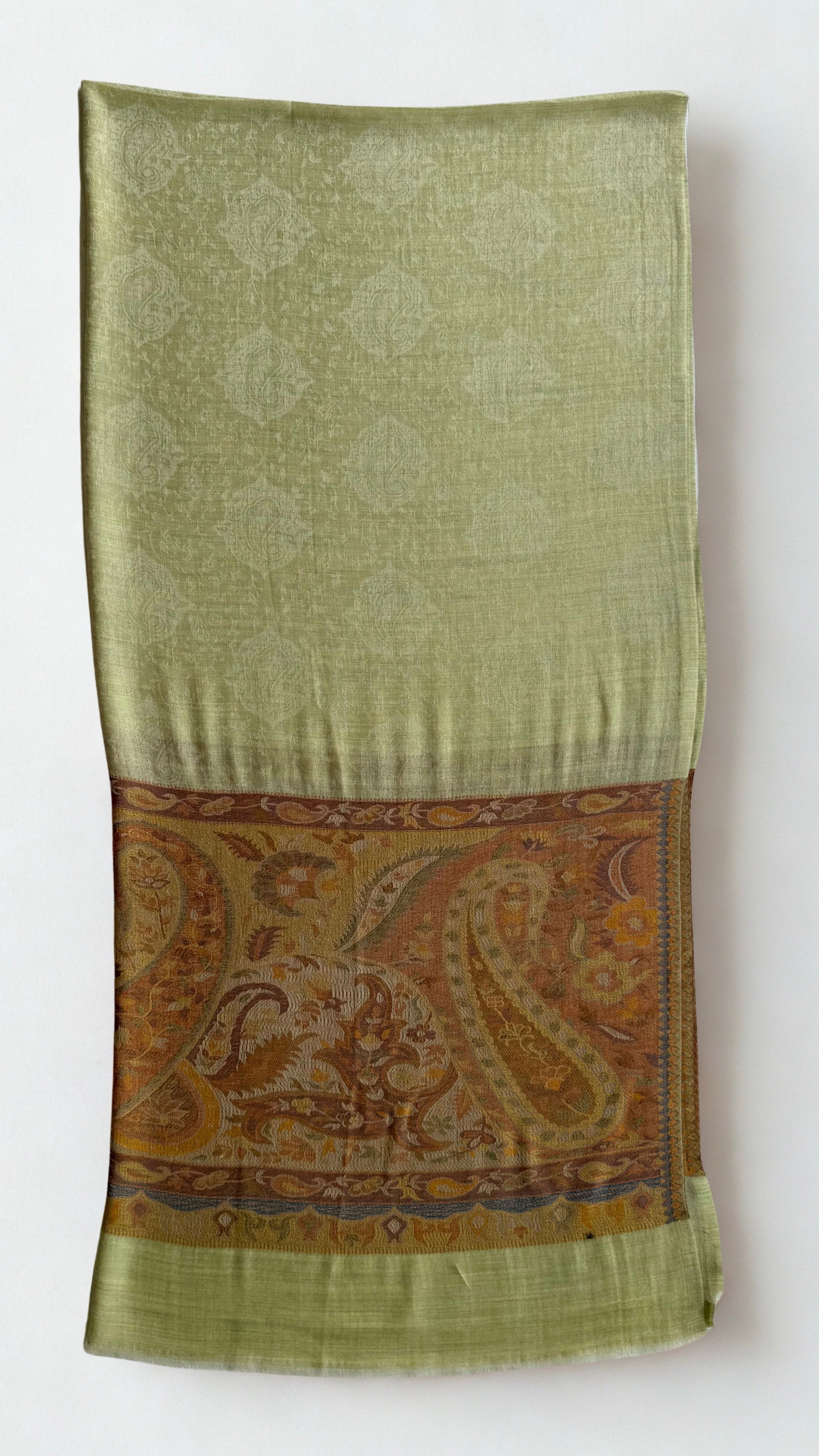 Close view of the sweeping paisleys in amber, ochre and rust on a warm brown ground