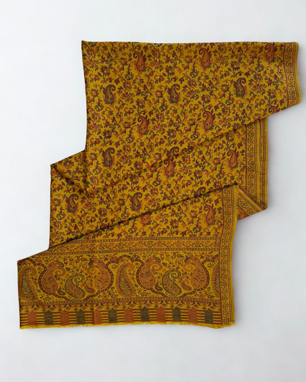 Mustard Kani pashmina shawl laid flat, handwoven paisley and floral field with a wide patterned end border