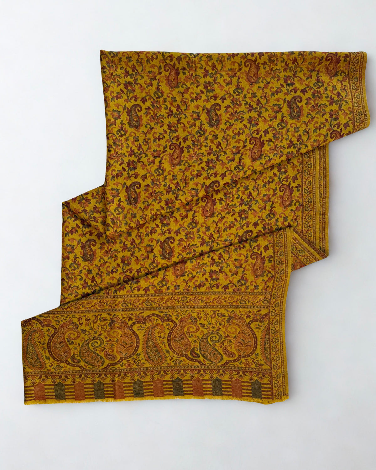 Mustard Kani pashmina shawl laid flat, handwoven paisley and floral field with a wide patterned end border