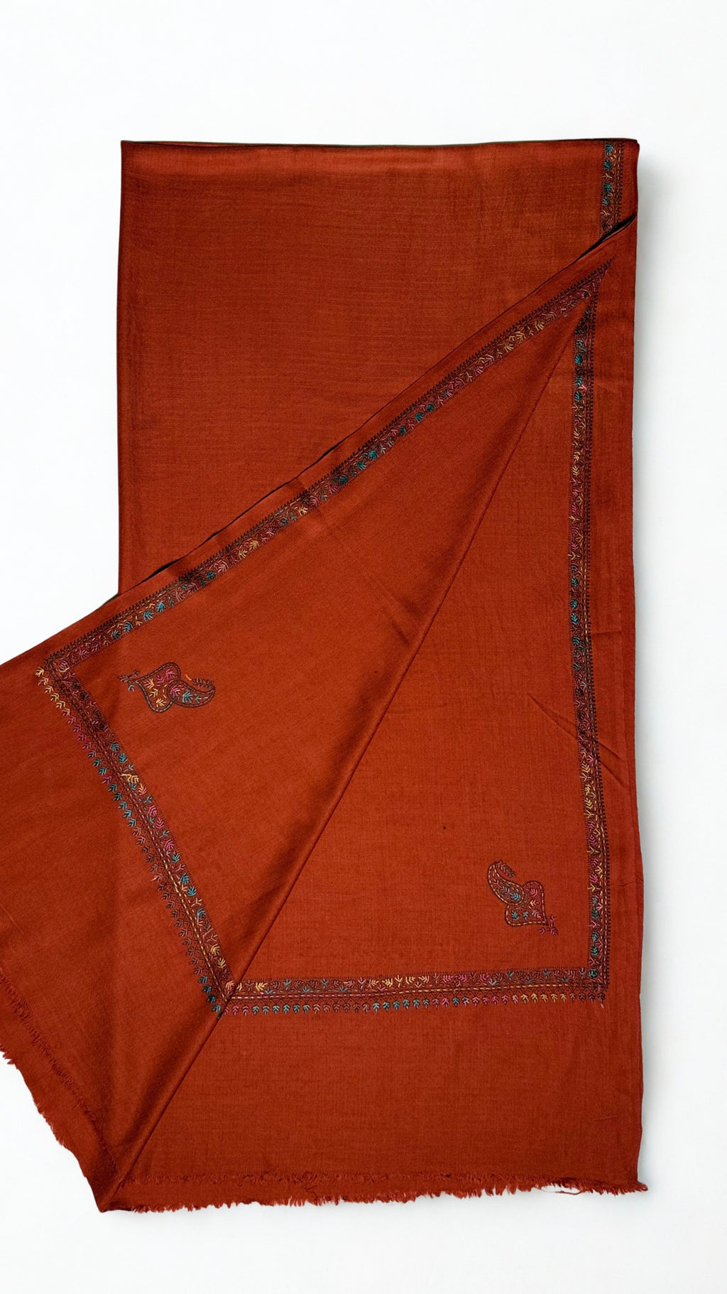 Rust Swati Shahtoosh shawl folded lengthwise, fine teal and rose hand-embroidered border with a paisley corner buta