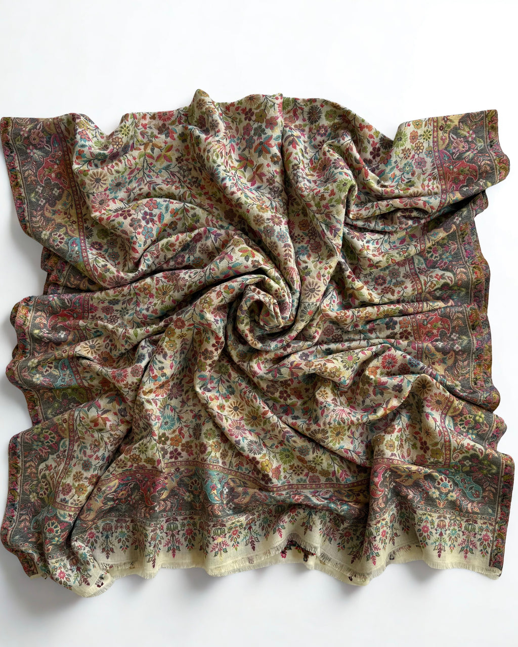 Corner detail of an ivory Zari Kani pashmina shawl, showing the slate border meeting the fringed end band