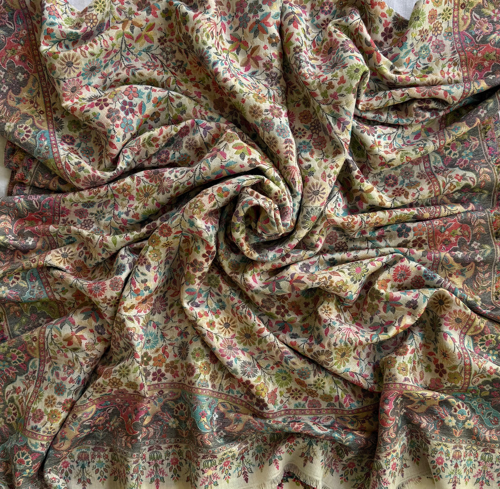 Ivory Zari Kani pashmina shawl folded to show the slate border, floral field and fringed pelmet band