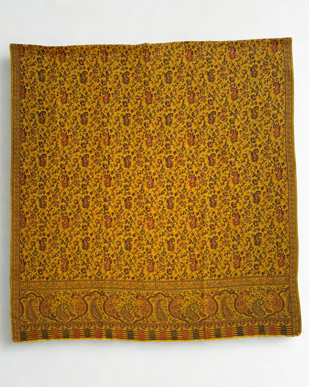 Mustard Kani pashmina shawl draped in soft folds, showing the woven paisley pattern and border