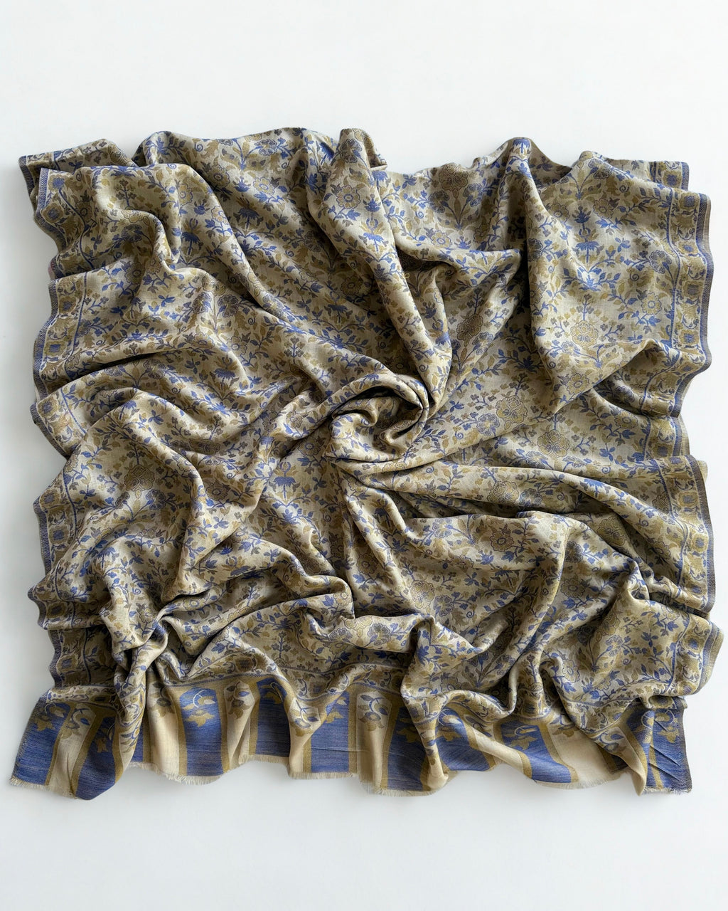 Close view of the Kani handwoven cobalt and olive flowering sprays on an ivory pashmina ground