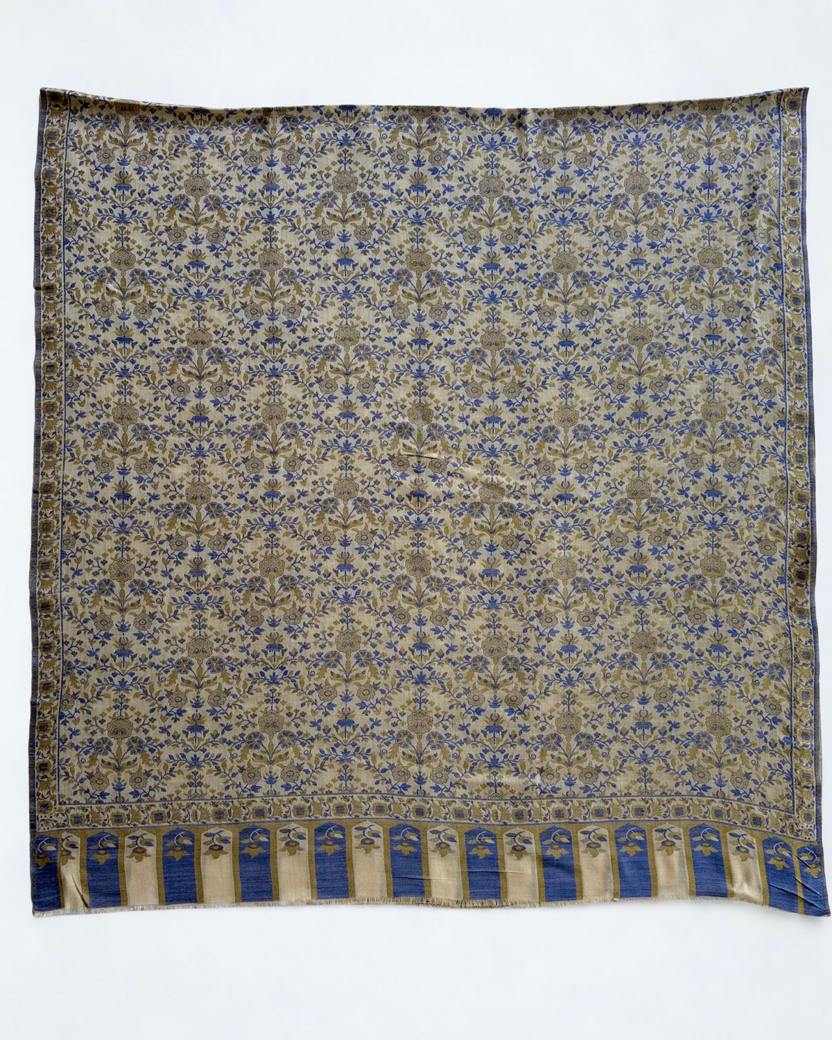 Ivory Kani pashmina shawl folded to show the deep arched border woven in cobalt and olive