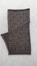 Stone-grey Kani pashmina shawl laid flat, fine navy paisley across the field with a deep ornamented end border