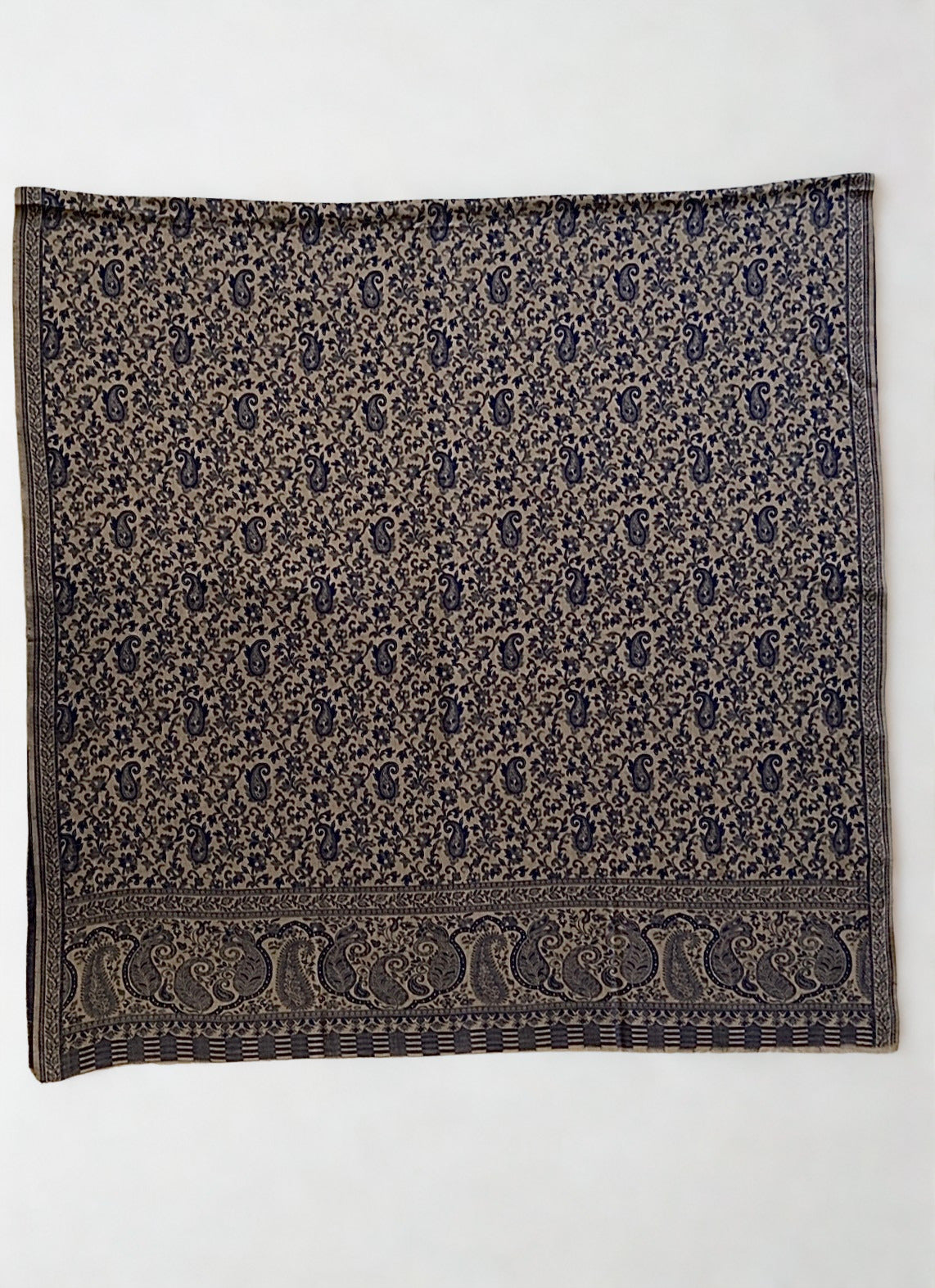 Stone and navy Kani pashmina shawl folded to show the woven paisley border and striped end panel