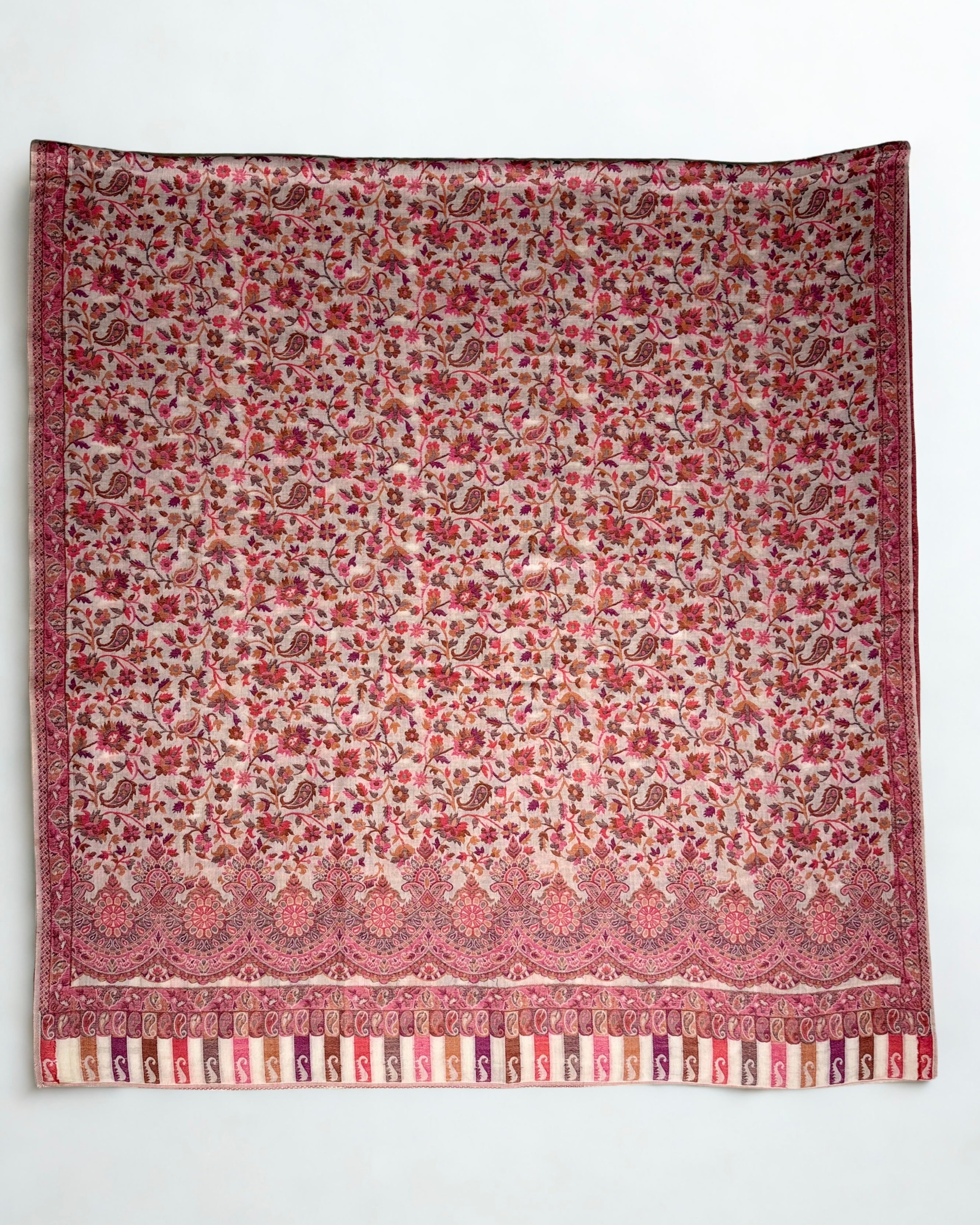 Close view of the rose and terracotta Kani floral weave falling in soft pleats from a hanger