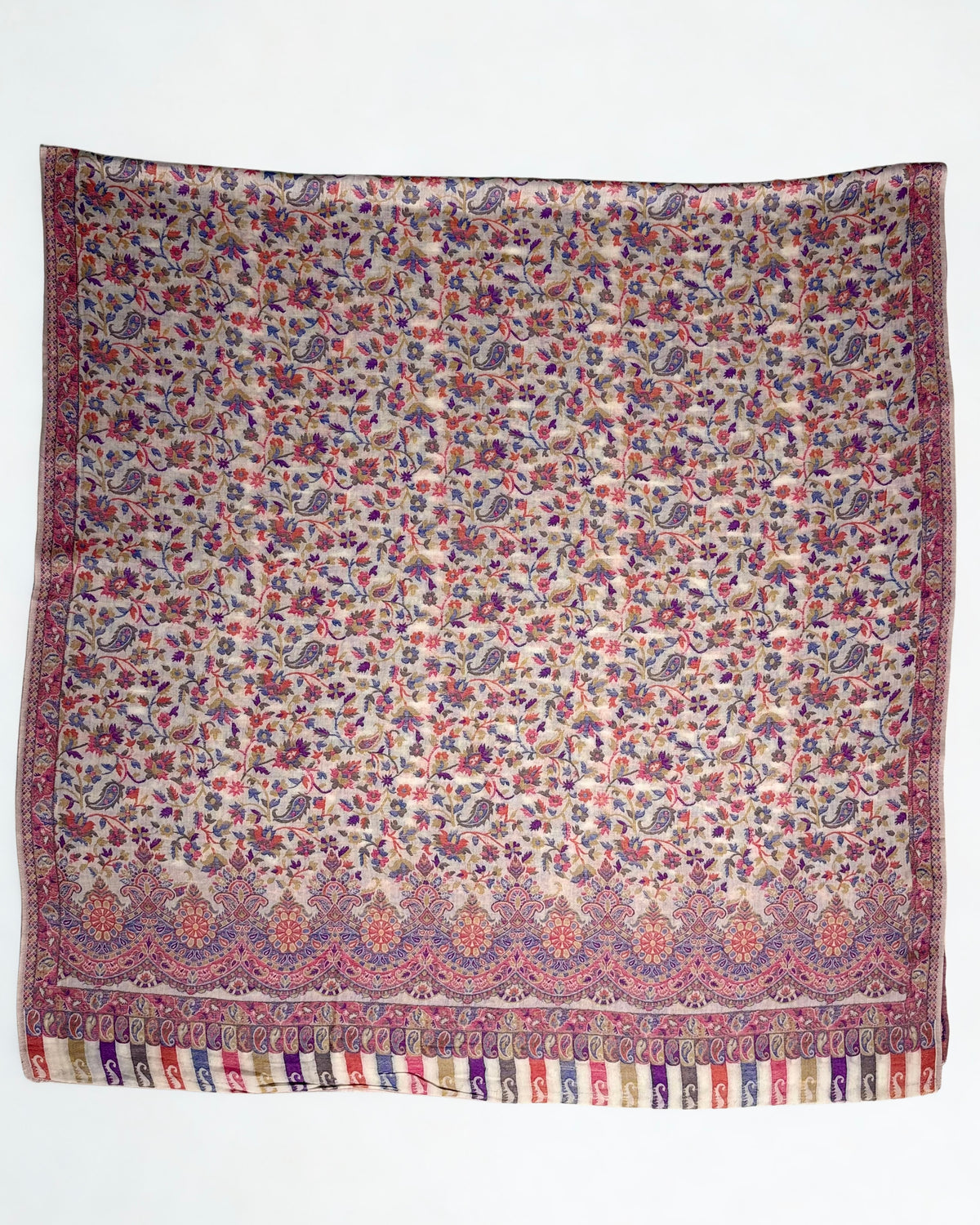 Detail of the scalloped medallion border and striped paisley end panel on an almond Kani pashmina shawl