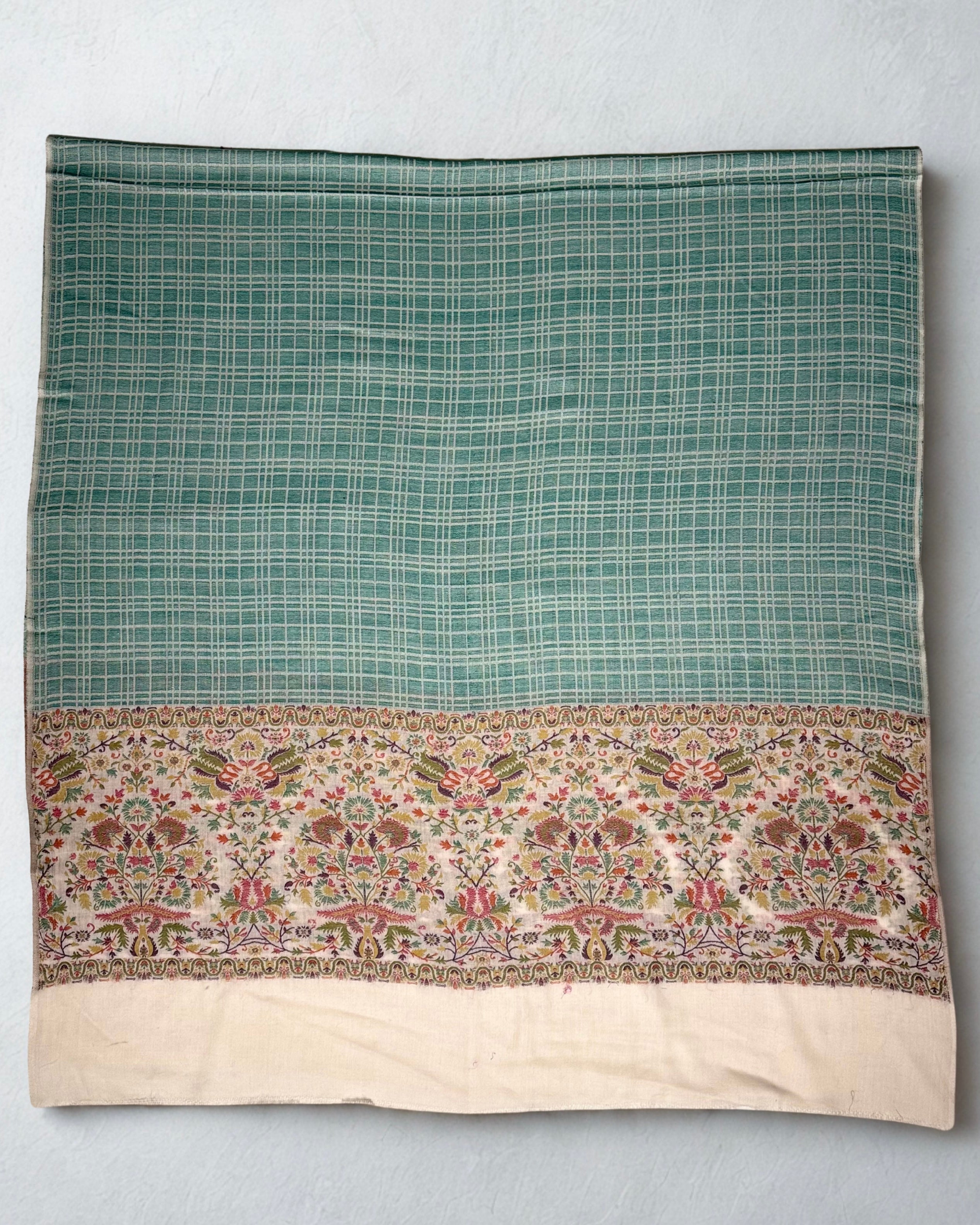 Sea green check Kani pashmina shawl folded to show both ivory floral end borders and the plain cream panels