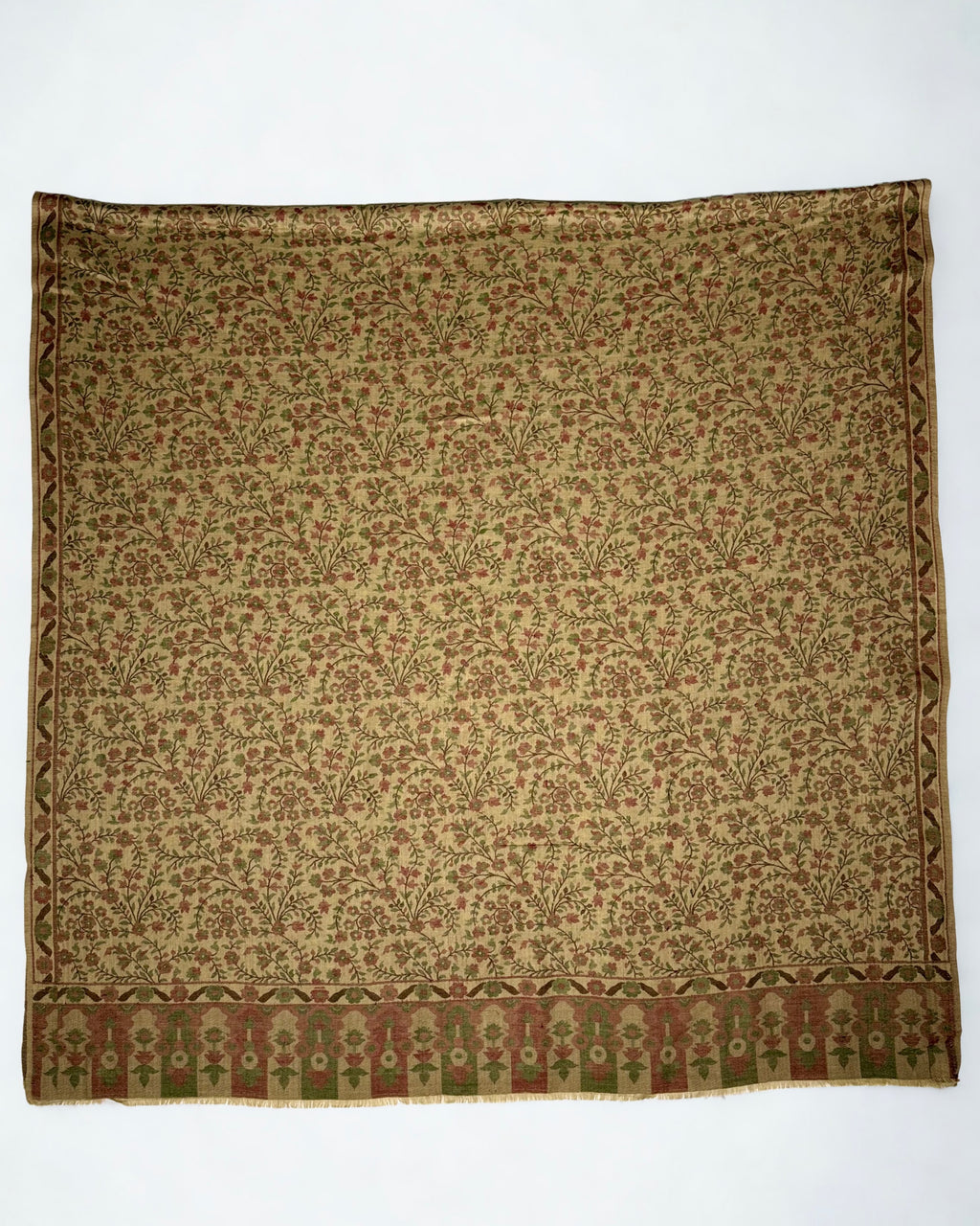 Antique gold Kani pashmina shawl folded back to show the reverse of the handwoven floral pattern and the deep end border