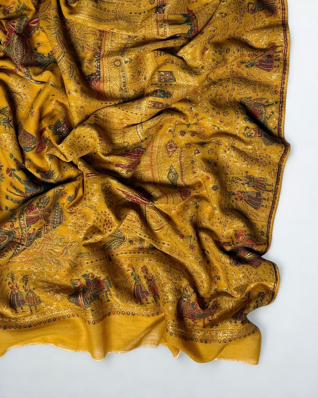 Detail of gold zari palace arcades, cypress trees and elephants woven into the mustard pashmina field