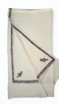 White Swati Shahtoosh shawl laid flat in soft pleats, showing the full embroidered border in rose, teal and gold
