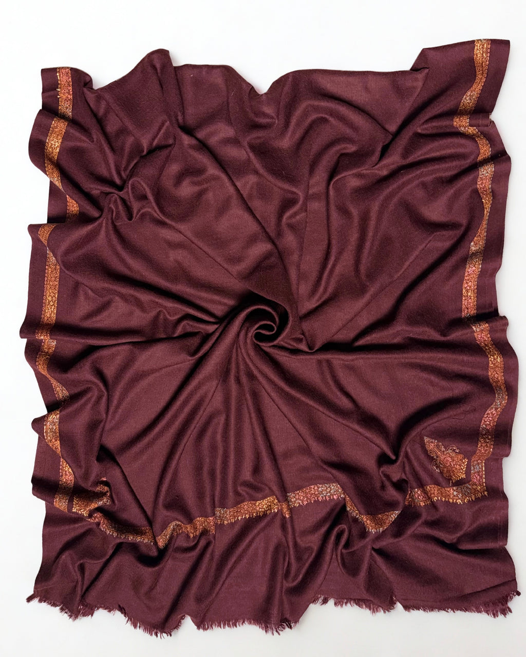 Deep maroon Swati Shahtoosh shawl in soft folds, gold border catching the light along the edge