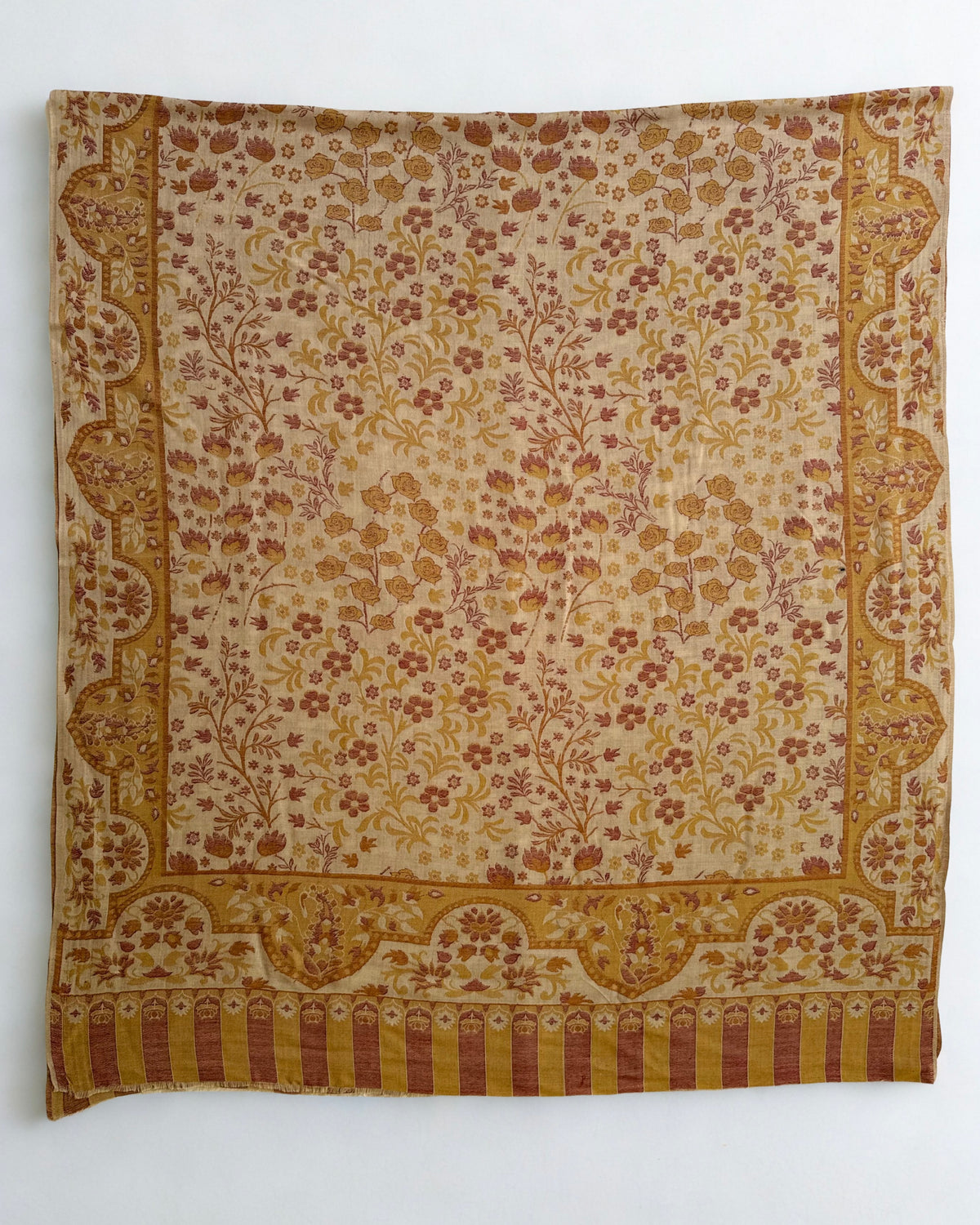 Sand and rose Kani pashmina shawl folded to show the scalloped paisley border meeting the striped colonnade end
