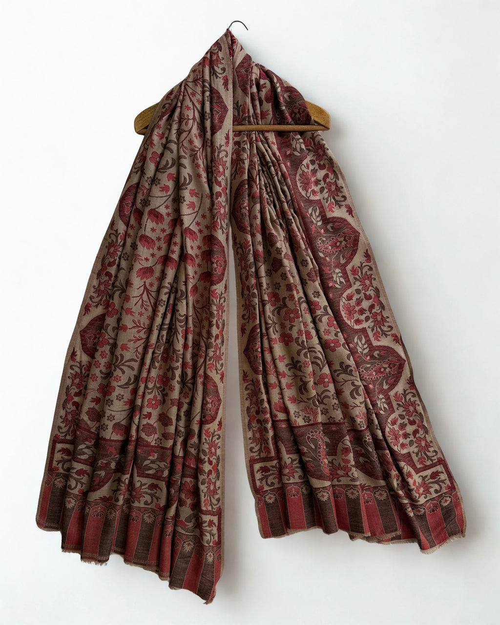 Taupe and rosewood Kani pashmina shawl draped over a wooden hanger, showing its full length and drape