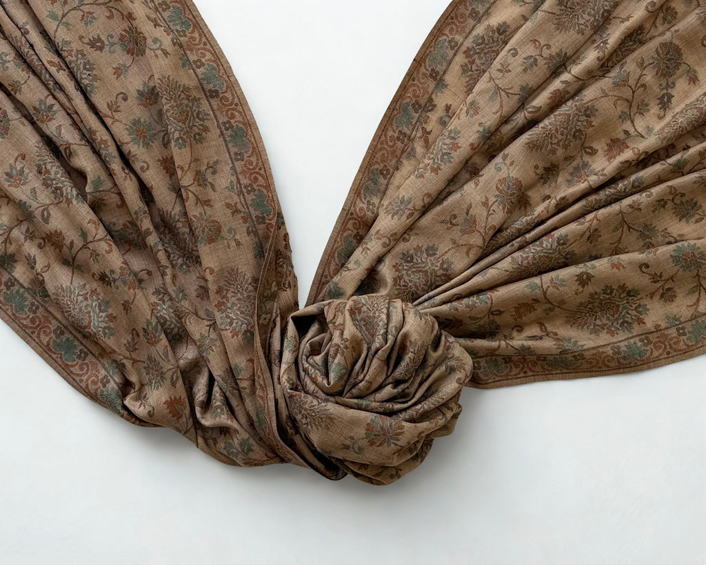 Camel and verdigris Kani pashmina shawl knotted and fanned out, showing the drape and the continuous vine pattern